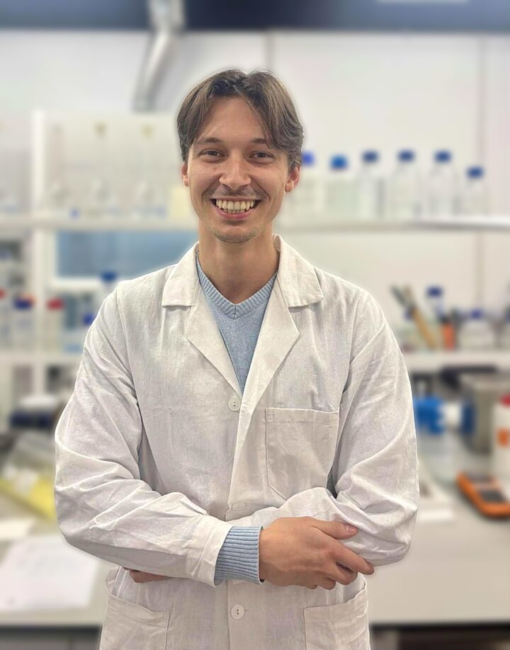 Portrait style image of a man in a white lab coat 